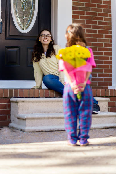 istock 2 year old daughter surprising mother with flowers 1187017638