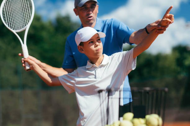 servizio di pratica istruttore di tennis con atleta junior - livello di sport foto e immagini stock