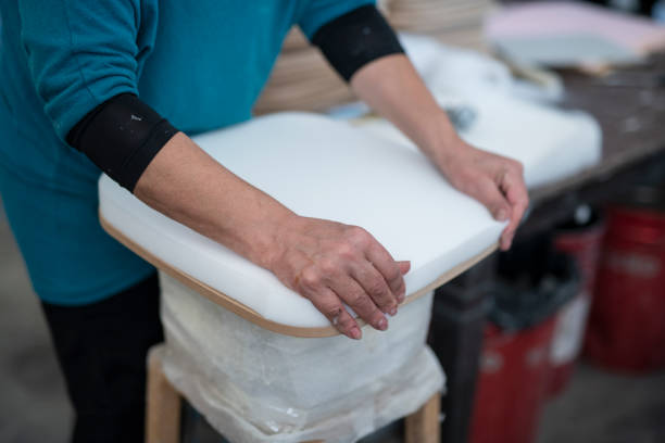 Unrecognizable woman upholstery worker working on chair in workshop