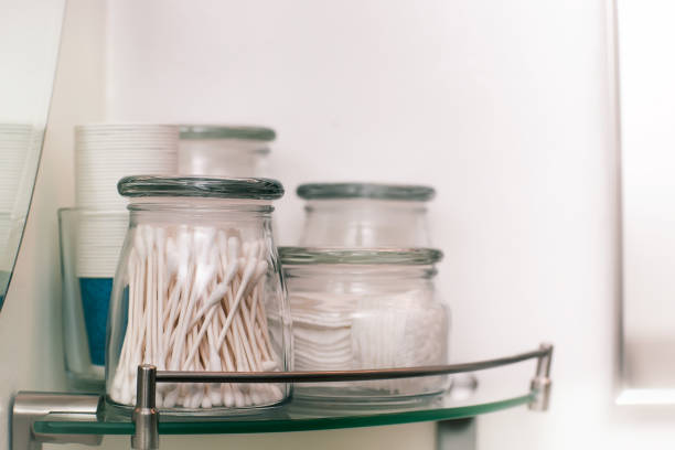 istock Makeup remover pads and cotton swabs on a modern glass shelf. 1187020260