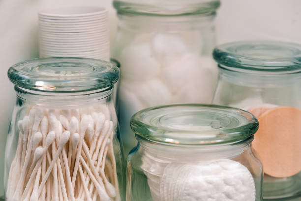 Sealed glass jars with makeup remover pads, cotton swabs and cotton balls for storage. stock photo