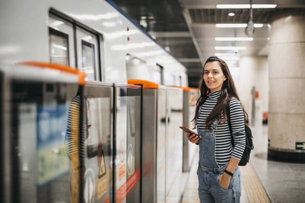 istock Young woman using mobile phone in the subway station 1187039527