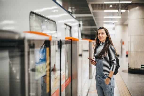 istock Young woman using mobile phone in the subway station 1187039542