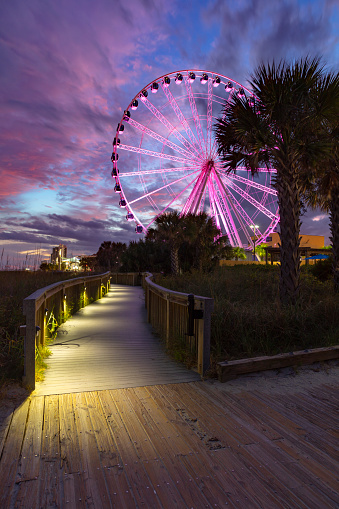 A view of the ferris wheel in Myrtle Beach from the boardwalk along the beach front.