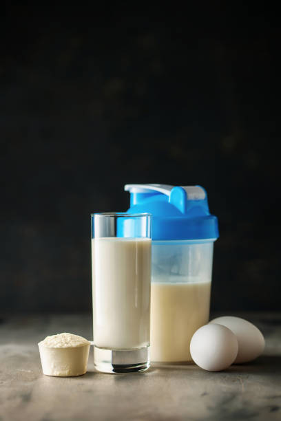 protein shake in bottle, powder, bars, eggs and measuring tape on dark background.  sport food concept. - body building milk shake protein drink drink imagens e fotografias de stock