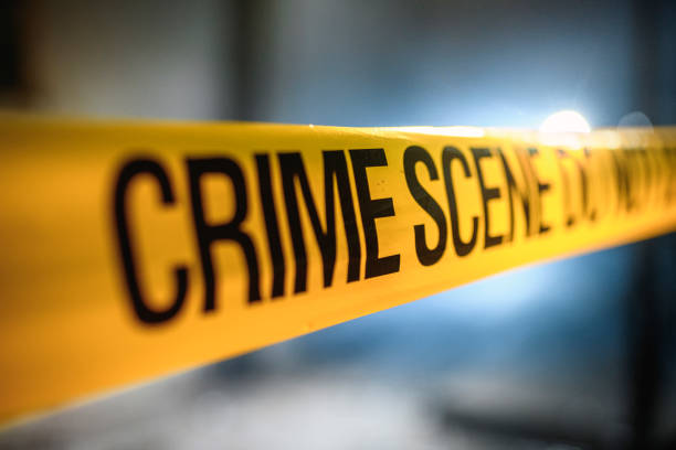 Close-up of yellow barricade tape installed at nighttime crime scene to establish boundary and protect evidence.