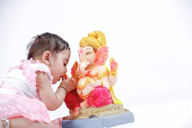 Indian  baby girl with lord ganesha and praying , Indian ganesh festival