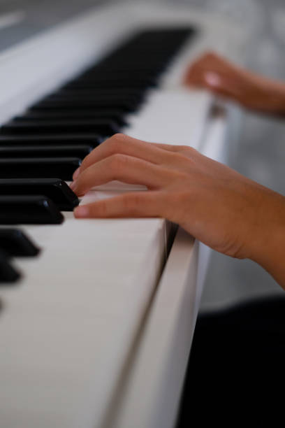istock Little girl playing the piano 1187064728