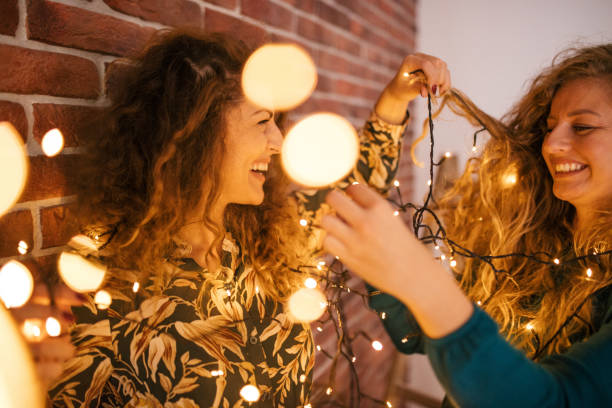 istock Girlfriends playing with christmas lights 1187074612