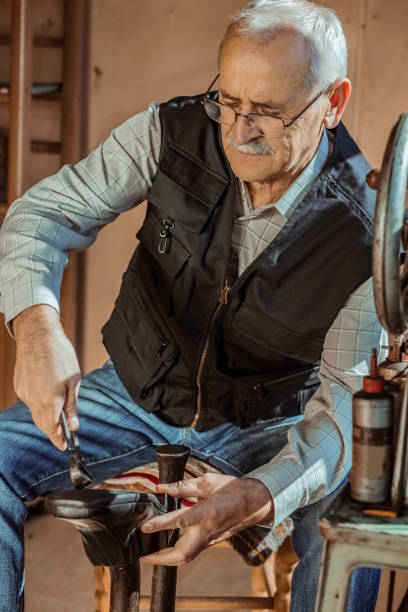 istock Shoemaker repairing and making shoes in workshop 1187074989