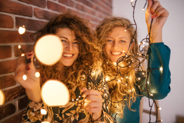 istock Girlfriends playing with christmas lights 1187075664