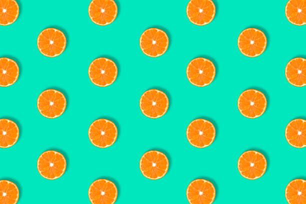 istock Fruit pattern of fresh mandarin slices on blue background. 1187076092