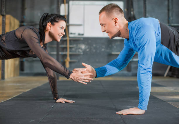 istock Sporty couple doing push ups together and giving five. 1187078295