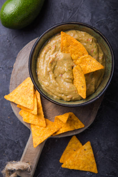 istock Corn nacho chips and avocado dip guacamole in bowl. 1187080903