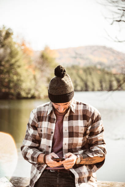 man on the phone in an autumn scene - hipster people surfing the net internet imagens e fotografias de stock