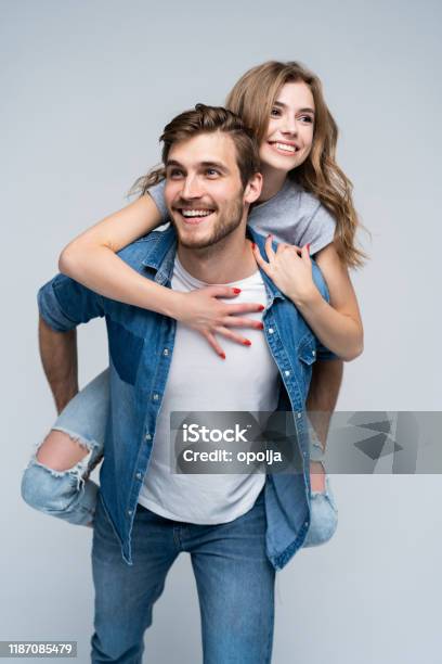 Nettes Porträt Des Paares Guy Rollt Ein Mädchen Auf Den Rücken Stockfoto und mehr Bilder von Paar - Partnerschaft