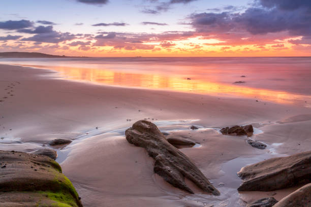 istock Sunrise and reflections on the beach in the morning 1187087238
