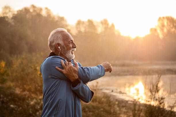 istock Mature man stretching arms getting ready for training looking at lake 1187088007