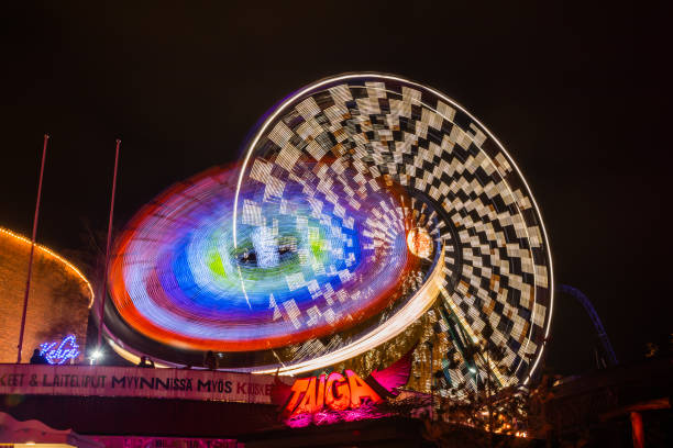 l'evento carnival of light al parco divertimenti linnanmaki. guida la ruota panoramica rinkeli e kehra in movimento, illuminazione notturna, lunga esposizione. - ferris wheel wheel night neon light foto e immagini stock
