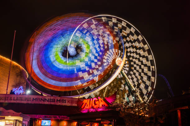 l'evento carnival of light al parco divertimenti linnanmaki. guida la ruota panoramica rinkeli e kehra in movimento, illuminazione notturna, lunga esposizione. - ferris wheel wheel blurred motion amusement park foto e immagini stock