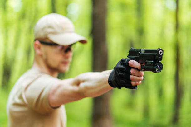 istock instructor with gun in forest leads aiming and posing on camera 1187088540