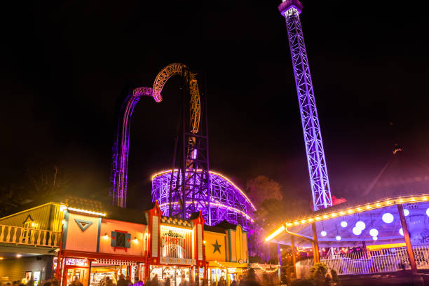 The Carnival of Light event at the Linnanmaki amusement park. Rides Raketti, Ukko and roller coaster Vuoristorata in night illumination. Helsinki, Finland - 19 October 2019: The Carnival of Light event at the Linnanmaki amusement park. Rides Raketti, Ukko and roller coaster Vuoristorata in night illumination. roller coaster line photos stock pictures, royalty-free photos & images