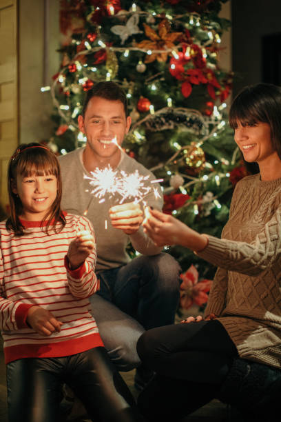 istock Happy family with Christmas tree and sparkles 1187089261