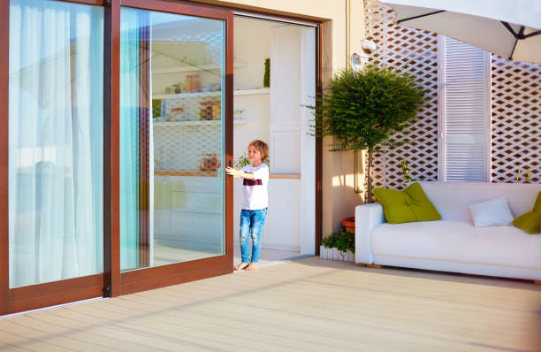 happy young boy, kid opening the sliding door on rooftop patio area at home happy young boy, kid opening the sliding door on rooftop patio area at home sliding door stock pictures, royalty-free photos & images