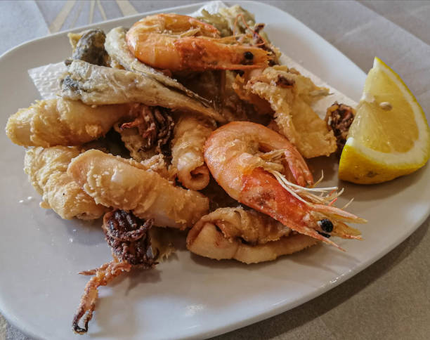 istock Mixed seafood and fish with lemon on a white plate 1187091612