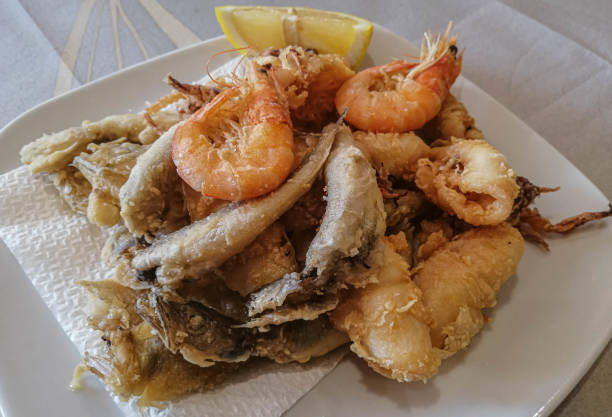 istock Mixed seafood and fish with lemon on a white plate 1187091646