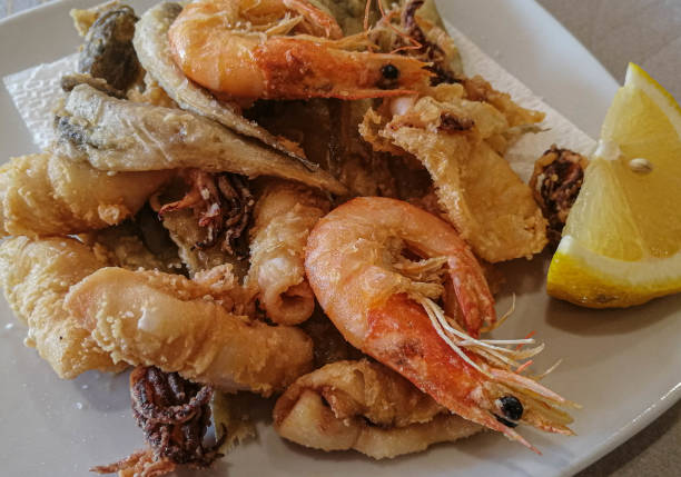 istock Mixed seafood and fish with lemon on a white plate 1187091659