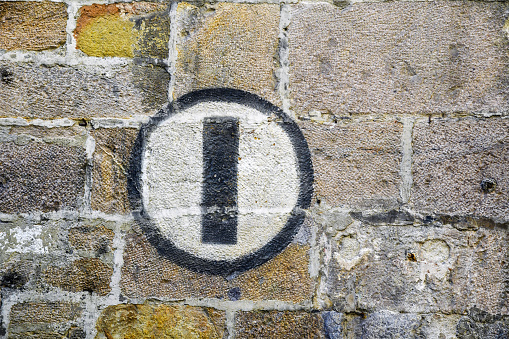 Close-up of an old brick wall with a painted World War II sign in the historic centre of Lucca, Tuscany, Italy