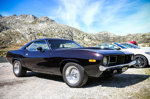 Saint Gotthard Pass, Switzerland - September 14, 2019: Black retro coupe car Plymouth Barracuda in the Swiss Alps.