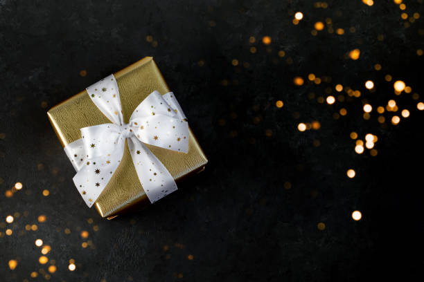 istock Gold gift box with a white ribbon. 1187099916