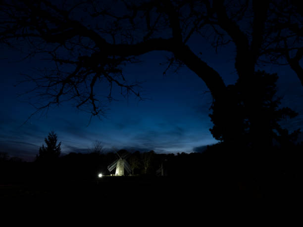 istock Rural night with small lit windmill visible 1187101386