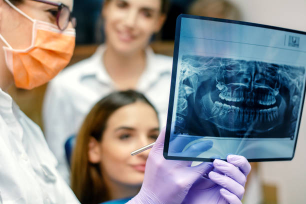 dentist showing an x-ray result - dentist dental hygiene dental assistant dentist office imagens e fotografias de stock