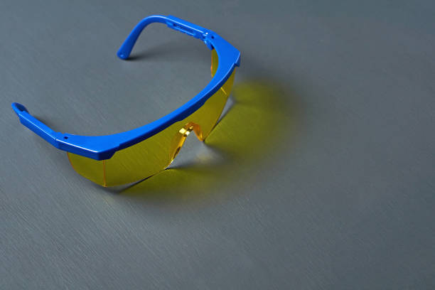 istock Ski goggles or modern protective glasses for worker on building, welder, dentist, turner and other with yellow glass and blue frame lies on dark concrete desk. Space for text 1187105462