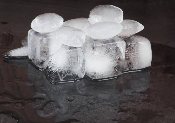 istock ice cubes on black table background with water drops. 1187107225