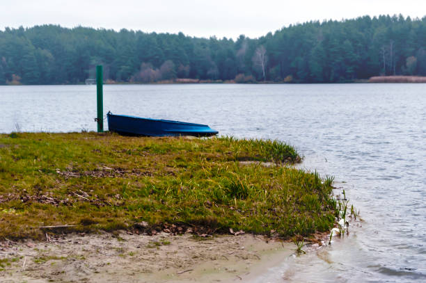 Lake in autumn time, shore, boat and forest