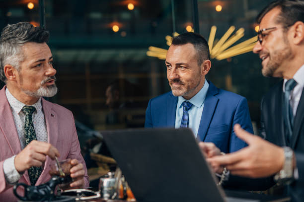 istock Businessmen sitting in sidewalk cafe 1187109939