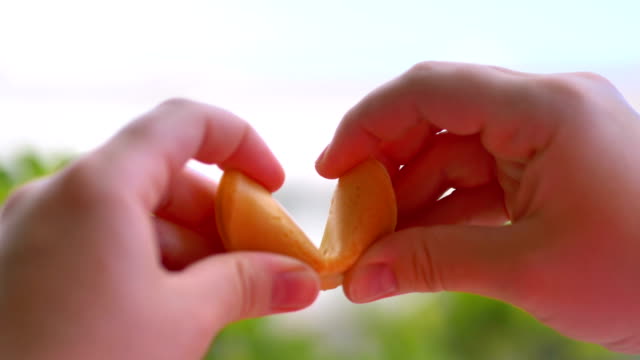 Opening chinese fortune cookie with a card inside in 4k slow motion 60fps
