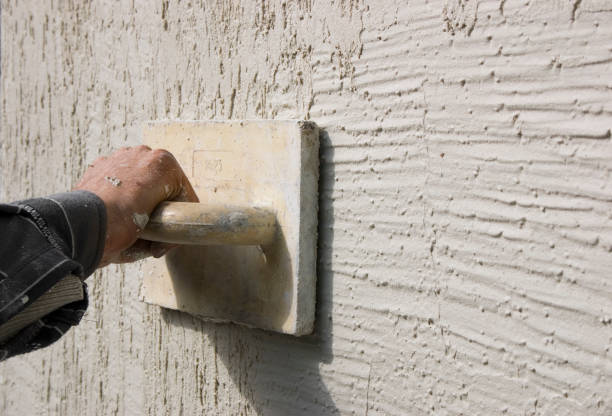 Plasterer inflicts decorative plaster Fragment of the wall of the house with applied decorative plaster and the hand of plasterer's with tool putty stock pictures, royalty-free photos & images