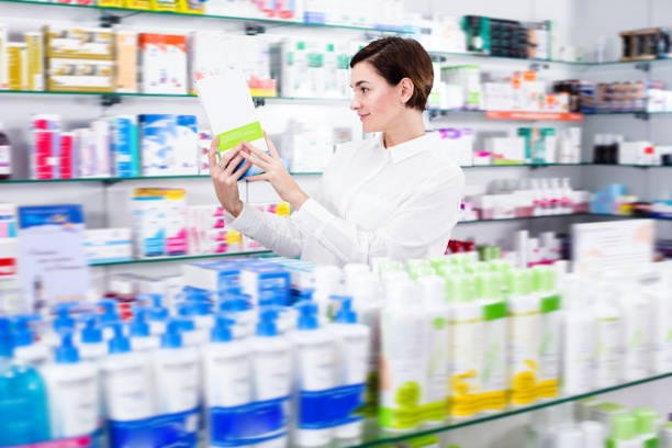 istock Smiling woman customer browsing rows of drugs 1187111440
