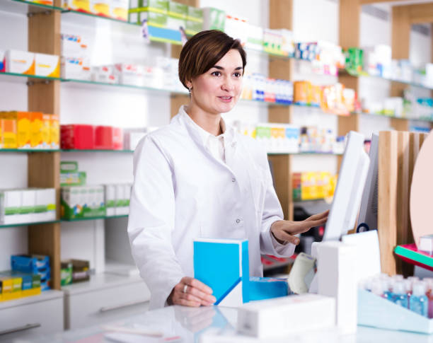 istock female pharmacist offering assistance at counter in pharmacy 1187111449