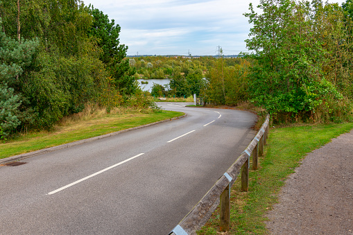 A curved road leads down to a lake in Derbyshire near Chesterfield.