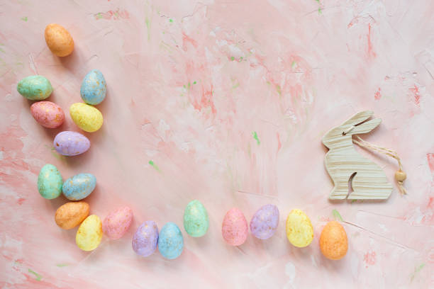 istock Multicolored eggs and rabbit decoration on a pink background. Easter celebration concept. 1187113261