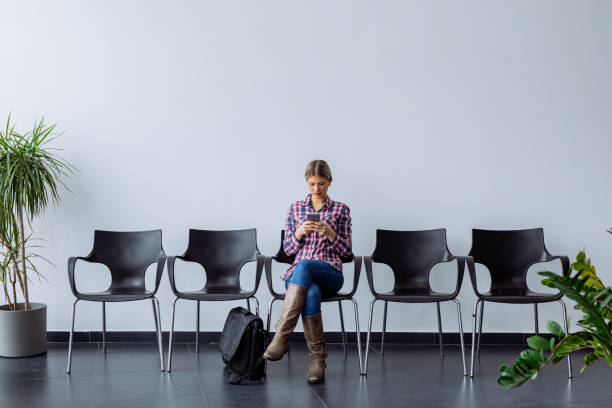istock Young female candidate using mobile phone while waiting for job interview 1187114192