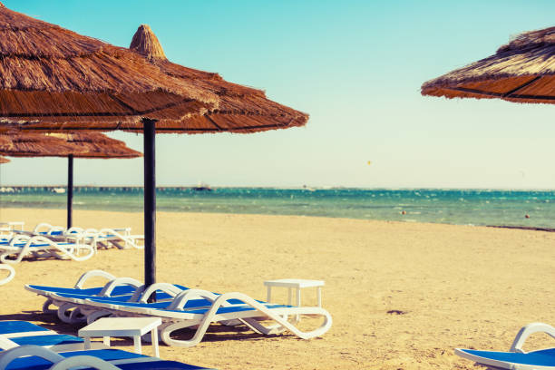 istock Beach with straw umbrellas and sunbeds. Vacation concept. 1187115181