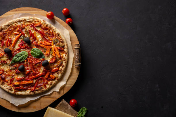 istock chicken tomato pepper pizza with olives and basil, top-view, with space on the side 1187116129