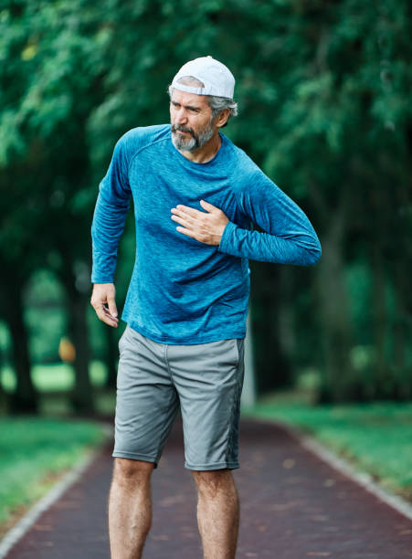 senior man running exercising sport fitness chest pain heart attack portrait of a senior man exercising and running outdoors having cardio problems chest pain male chest pain stock pictures, royalty-free photos & images